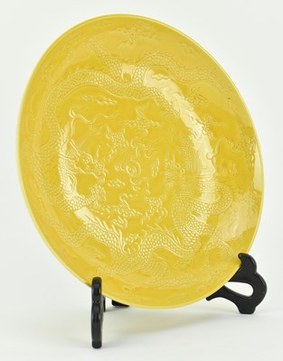 Lot 130 - HONGZHI MARKED INCISED YELLOW GLAZED DRAGON CHARGER 大明弘治款黄地暗花龙纹盘