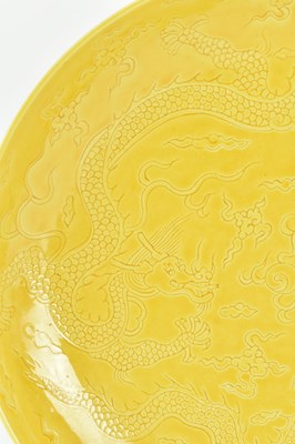Lot 130 - HONGZHI MARKED INCISED YELLOW GLAZED DRAGON CHARGER 大明弘治款黄地暗花龙纹盘