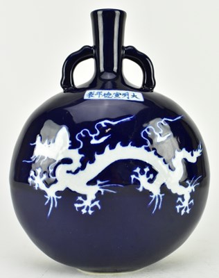 Lot 110 - MING MARK BLUE AND WHITE REVERSE DECORATED MOON FLASK VASE 霁蓝釉留白龙纹抱月瓶